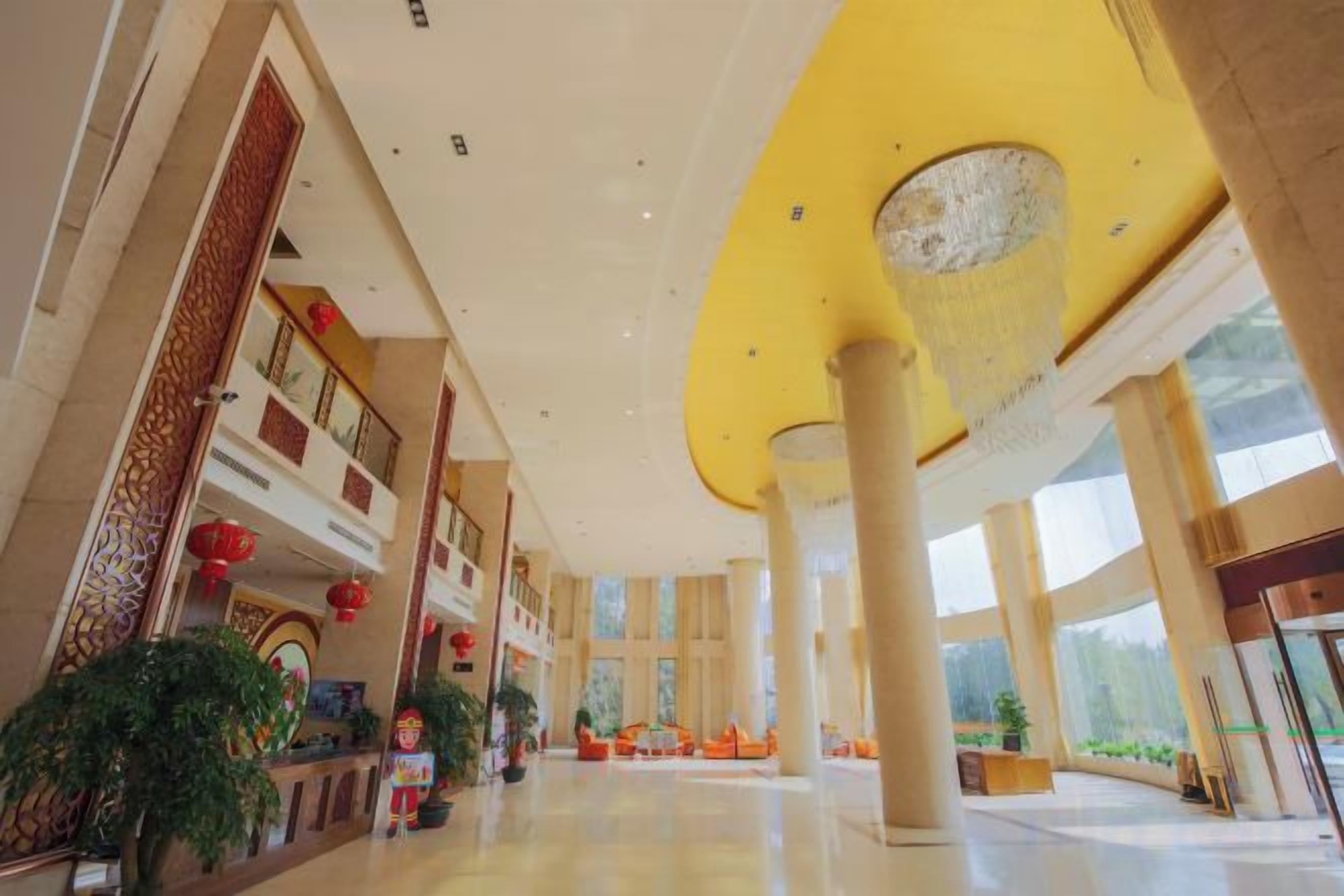 A spacious lobby with high ceilings, large windows, and a central column.