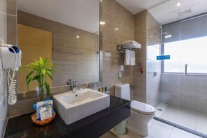 A modern bathroom with a large sink, a toilet, a glass shower enclosure, and a potted plant. - Shan Shui Xiang Ge Li La Hotel (Dingnan)