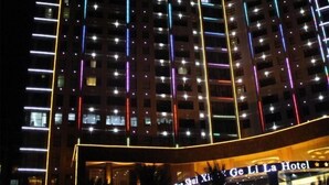 Un hôtel à la façade moderne, illuminée par des néons verticaux.