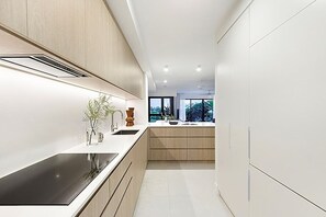 Cozinha moderna com ilha central, armários embutidos e vista para o exterior.