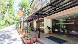 A building with a covered entrance, potted plants, and a clear sky. - Areca Boracay Bed & Breakfast (Boracay Island)
