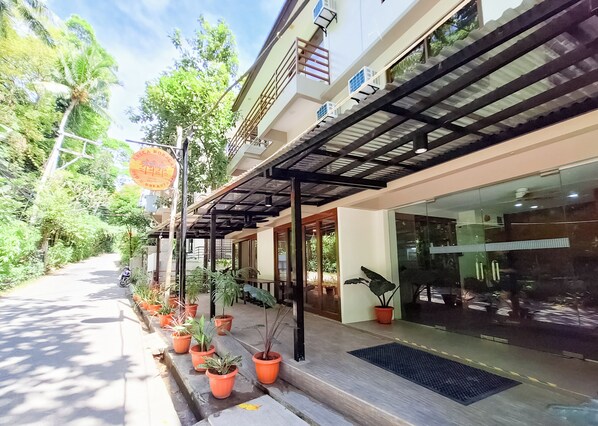 A building with a covered entrance, potted plants, and a clear sky. - Areca Boracay Bed & Breakfast (Boracay Island)