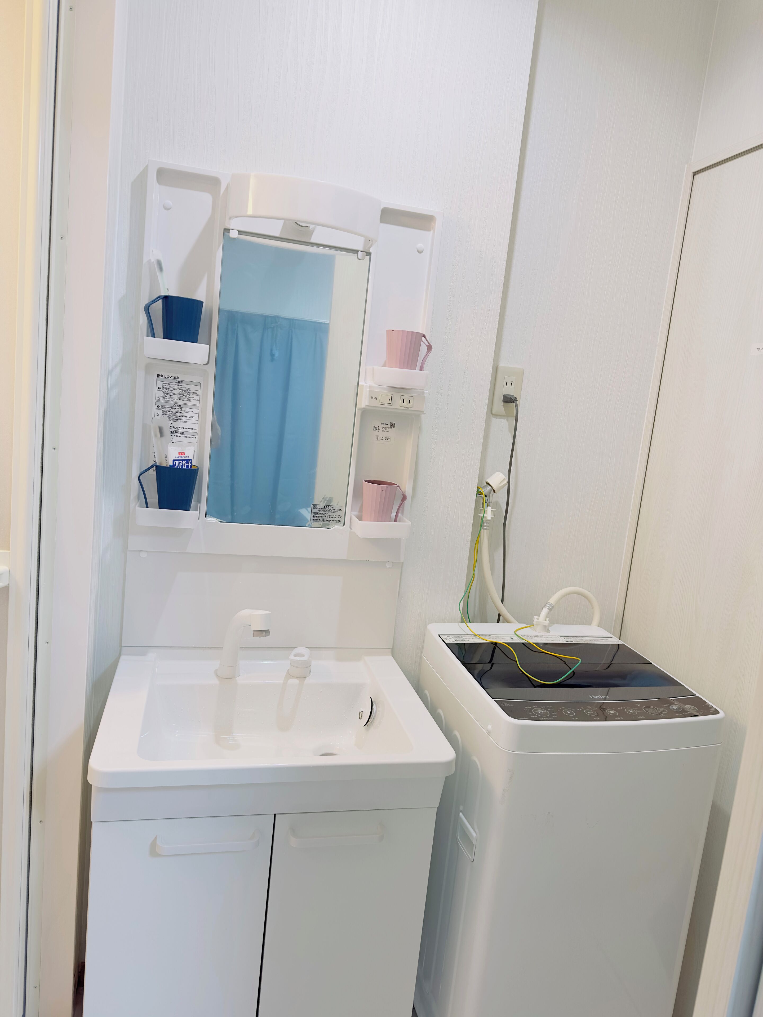 A bathroom with a white sink, a mirror, and a white heater.