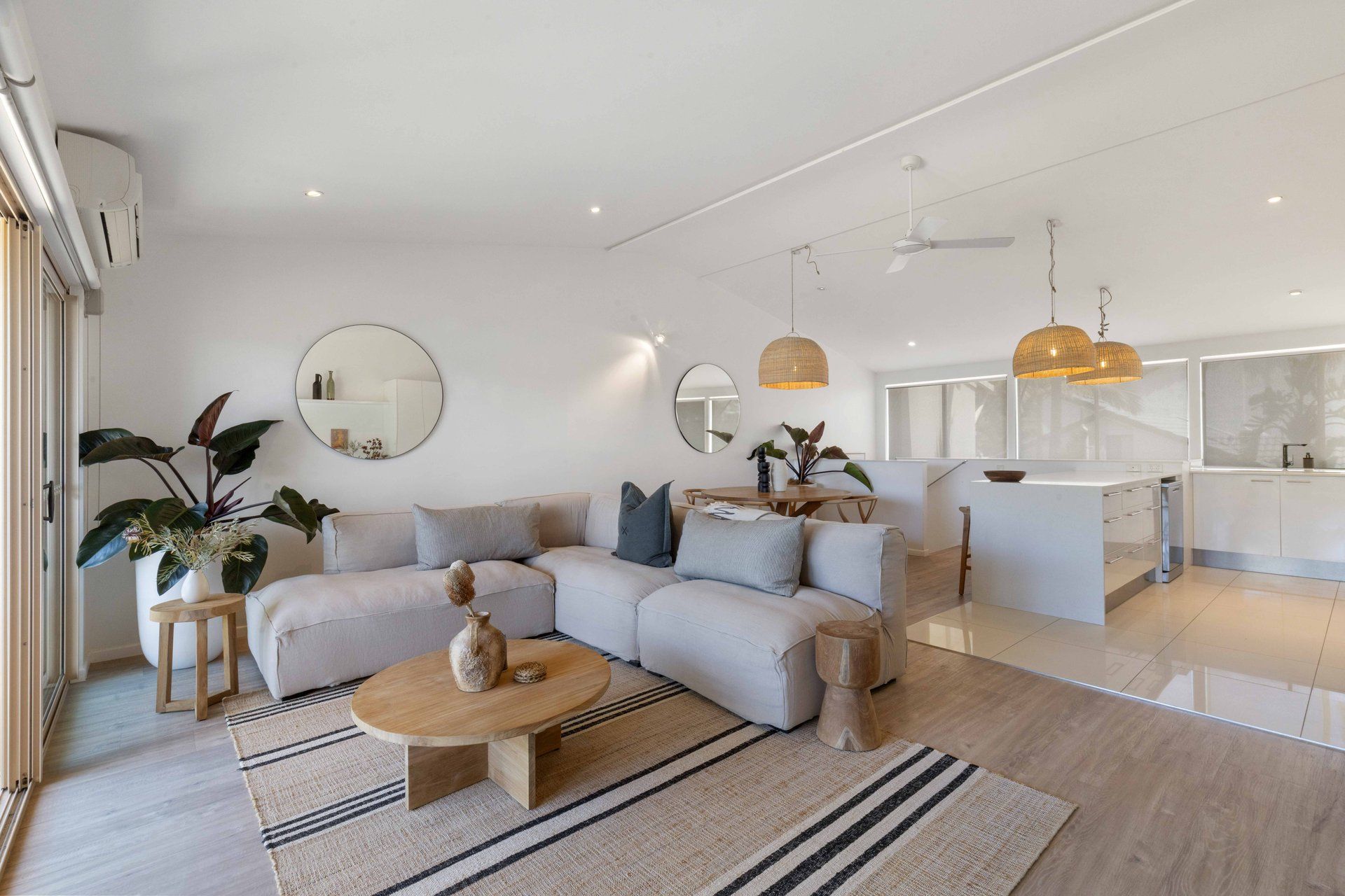 Una sala moderna con sofá, mesa de centro y comedor con isla de cocina.