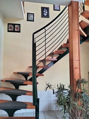 A spiral staircase with wooden steps and black railings, leading to an upper floor. - Apartment Linde with Shared Garden and Wi-Fi (Suhl)