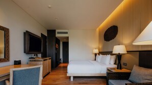 A hotel room with a bed, bedside tables, a TV, a desk, and a chair. - Sunyi Ubud (Payangan)