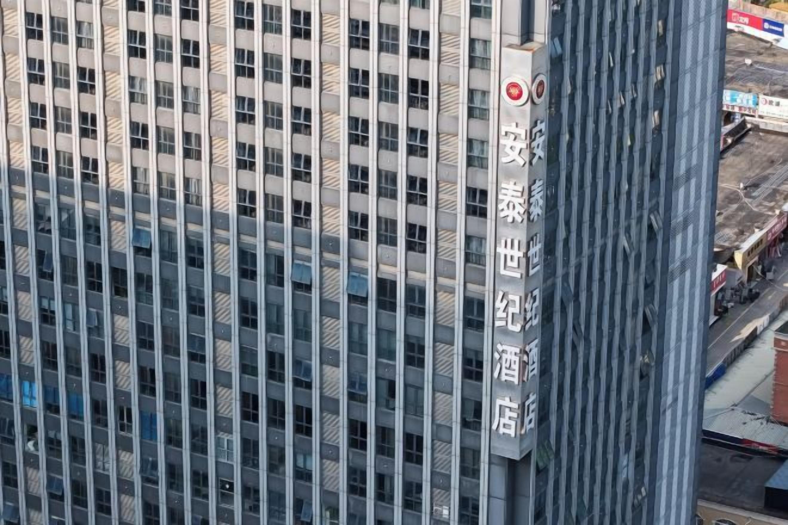 Um edifício alto com uma placa indicando que é um hotel.