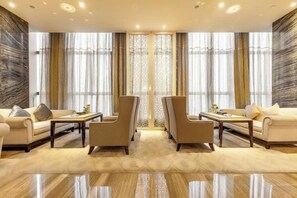 A spacious living room with a sofa set, two armchairs, a coffee table, and a decorative screen. - Antai Century Hotel (Chengdu)