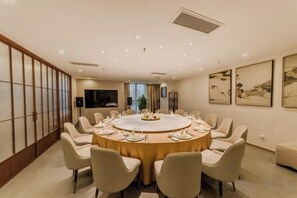 A conference room with a round table, chairs, and a television screen. - Antai Century Hotel (Chengdu)
