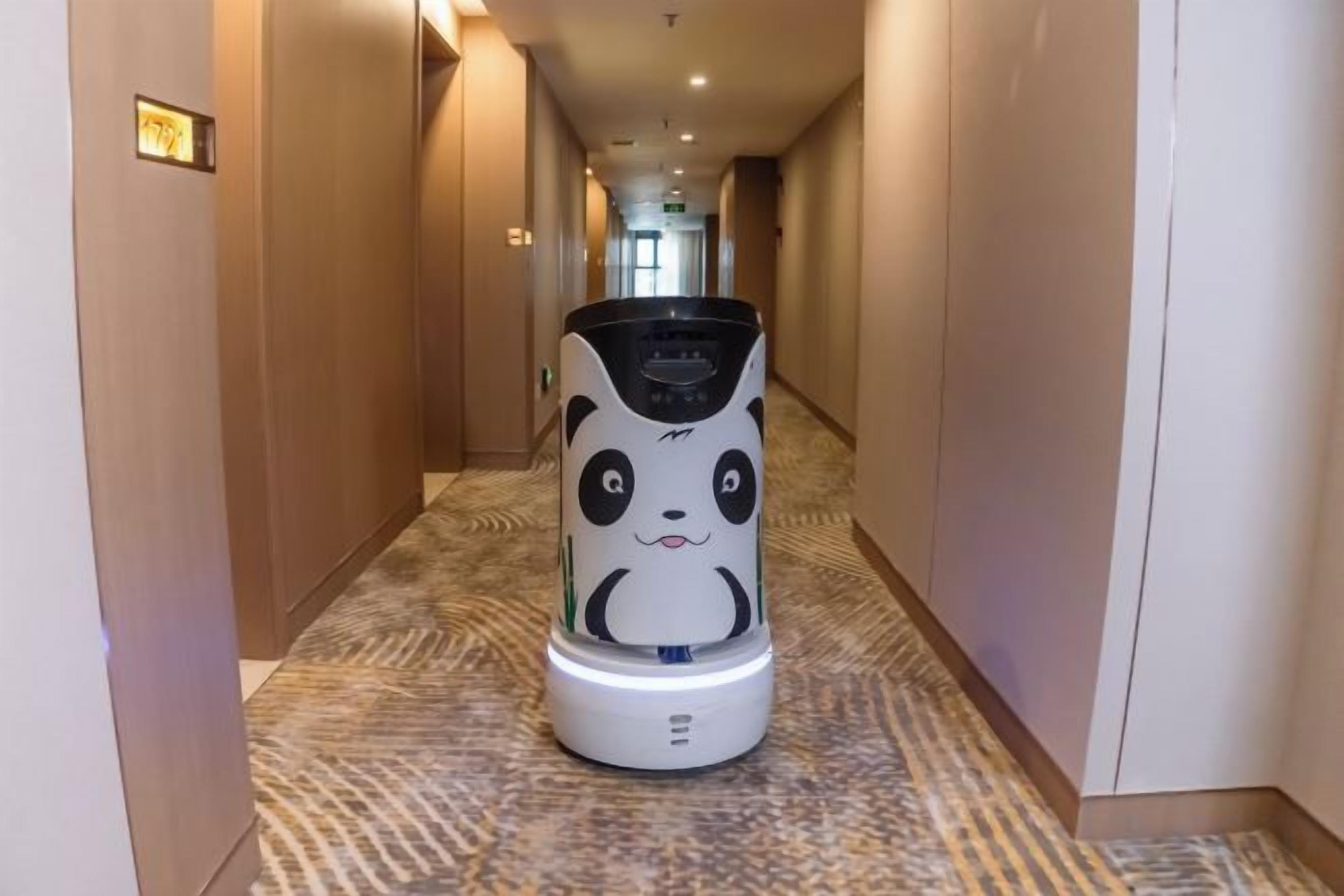 A hallway with a white, panda-themed robot.