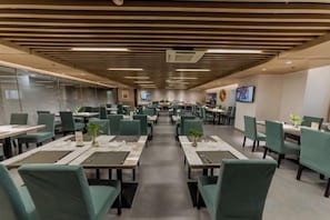 A spacious dining area with multiple tables and chairs, arranged in rows. - Antai Century Hotel (Chengdu)
