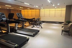 A gym with treadmills, exercise bikes, and weights. - Antai Century Hotel (Chengdu)