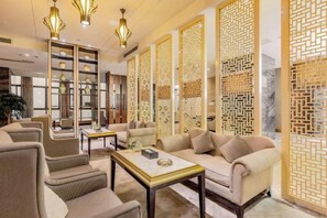 A modern living room with a sofa, armchairs, and a coffee table. There are decorative screens and a bookshelf. - Antai Century Hotel (Chengdu)