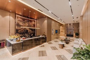 A modern lobby with a reception desk, seating area, and a decorative wall. - Antai Century Hotel (Chengdu)