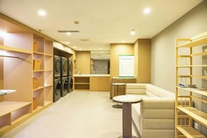 A hotel room with a kitchenette, a seating area, and a laundry facility. - Antai Century Hotel (Chengdu)