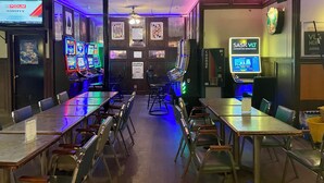 A gaming area with multiple arcade machines, tables, and chairs. - Outlook Motor Hotel (Outlook)