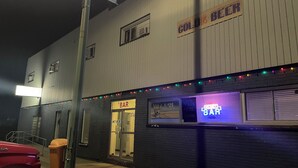 A bar with a neon sign, a 'Cold Beer' sign, and a '5$' price tag. - Outlook Motor Hotel (Outlook)