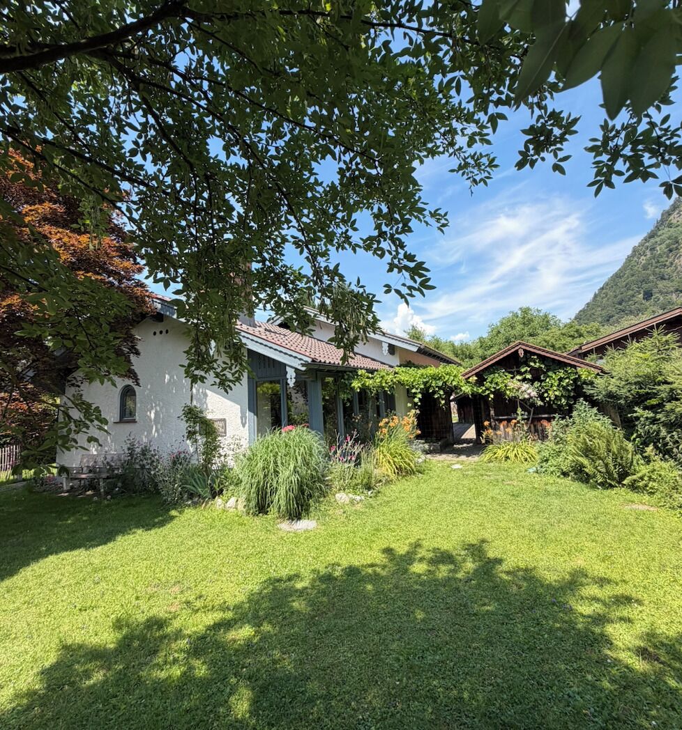 Ein Haus mit Garten, Terrasse und Bergblick.