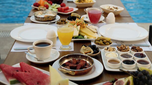 A breakfast buffet with a pool and waterfall view.