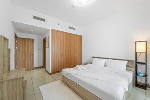 Une chambre à coucher moderne avec un grand lit, une armoire en bois et une table de chevet.