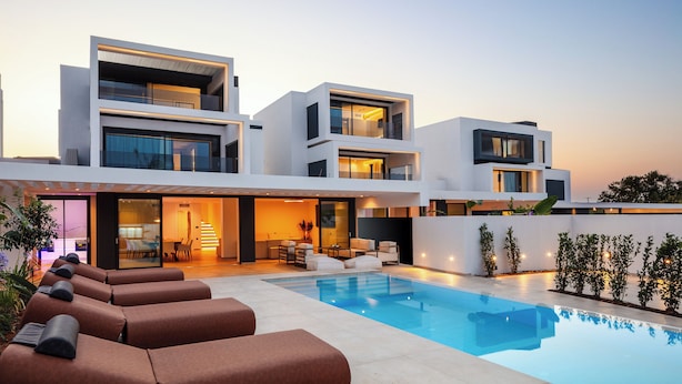 A modern multi-story house with a swimming pool, outdoor seating, and a well-lit interior. - Nuera II: Modern 4BR Villa, 300m from the Beach (Chania)