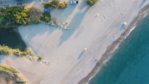 An aerial view of a beach with clear waters, a few people, and some trees. - Nuera II: Modern 4BR Villa, 300m from the Beach (Chania)