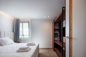 A modern bedroom with a bed, a wardrobe, and a nightstand. - Nuera III: Modern 3BR Villa, 300m from the Beach (Chania)