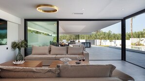 Un salon moderne avec un canapé, une table basse et une vue sur la terrasse extérieure.
