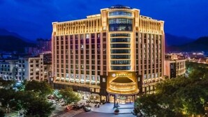 A multi-story hotel with a prominent central atrium and a curved glass facade. - Shexiang Hongbin Hotel (Jingning)