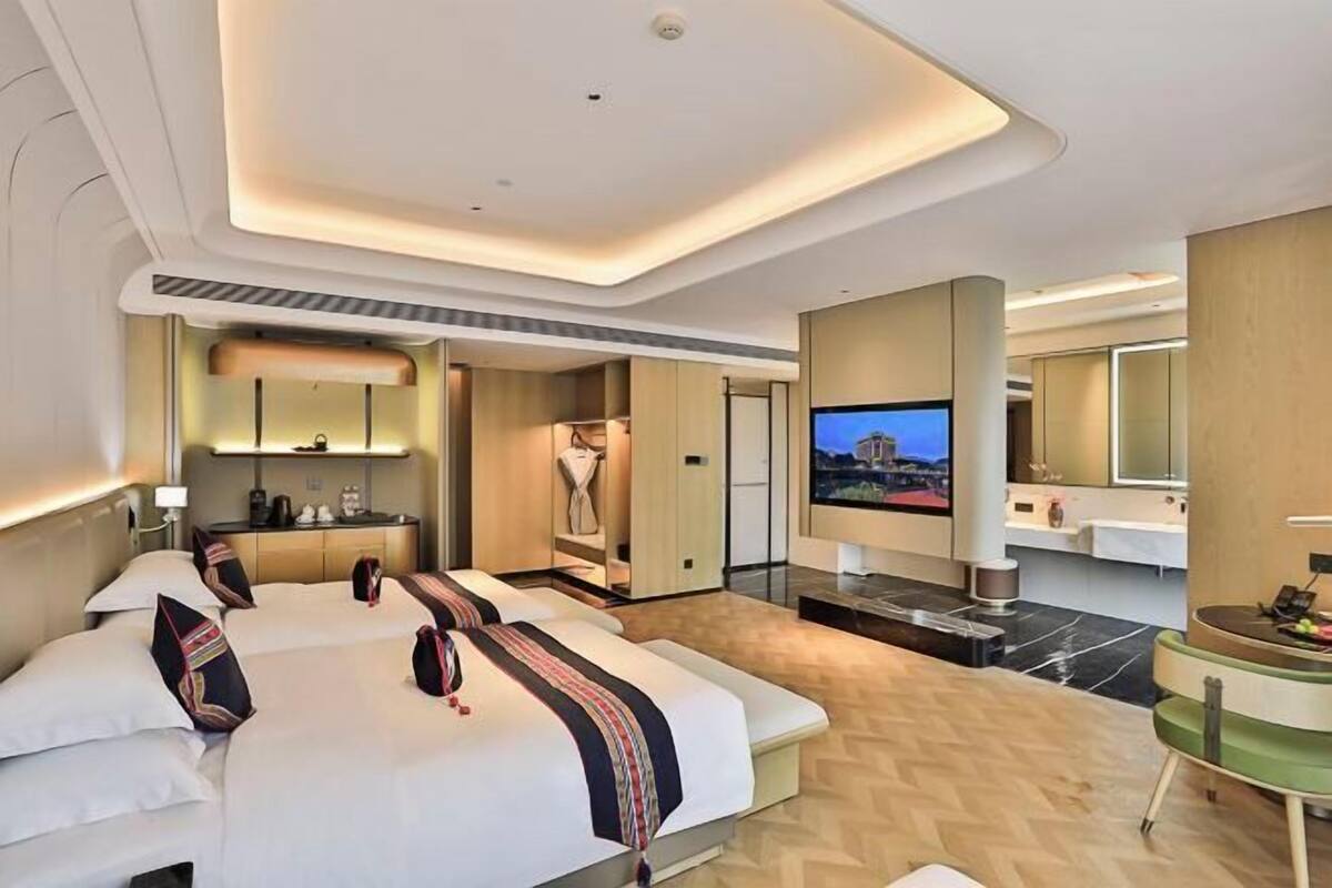 Une chambre d’hôtel avec deux lits, une télévision, une salle de bain et une petite kitchenette.