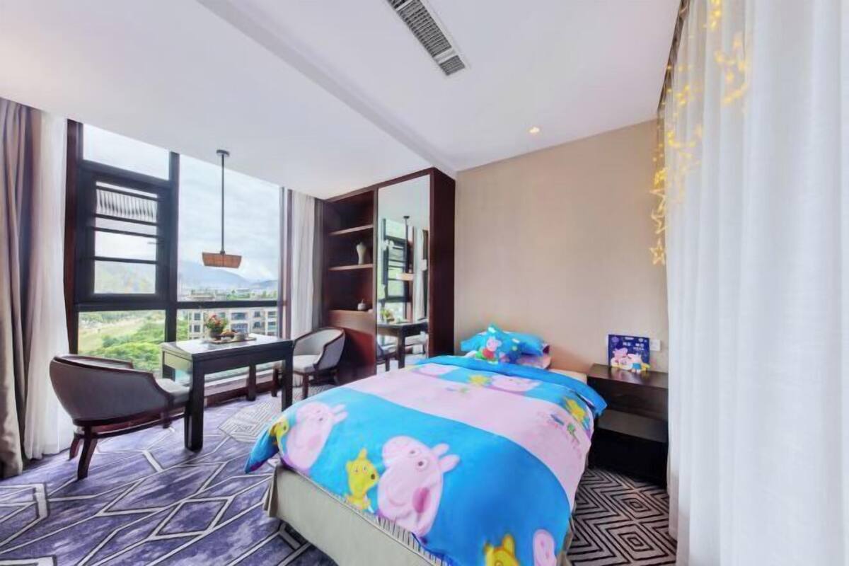 Une chambre d’hôtel avec un grand lit, un bureau, une chaise et une vue sur la ville.