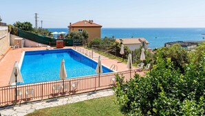 A swimming pool with a view of the sea, surrounded by a fence and greenery. - Sunny Home by Interhome (Santo Stefano al Mare)