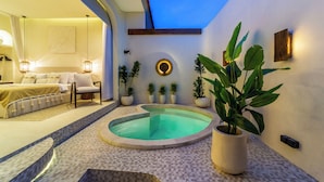 A modern hotel room with a pool, a bed, and a seating area. - OriVista Luxe 1BR Designer Pool Villa in Canggu (Canggu)