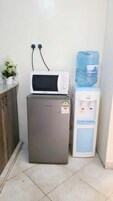 A compact kitchen with a Hisense refrigerator, a microwave, and a water dispenser.