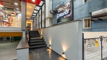 Una escalera conduce a un segundo piso con un letrero que dice 'Wandr by Sett'l' y un número de contacto.