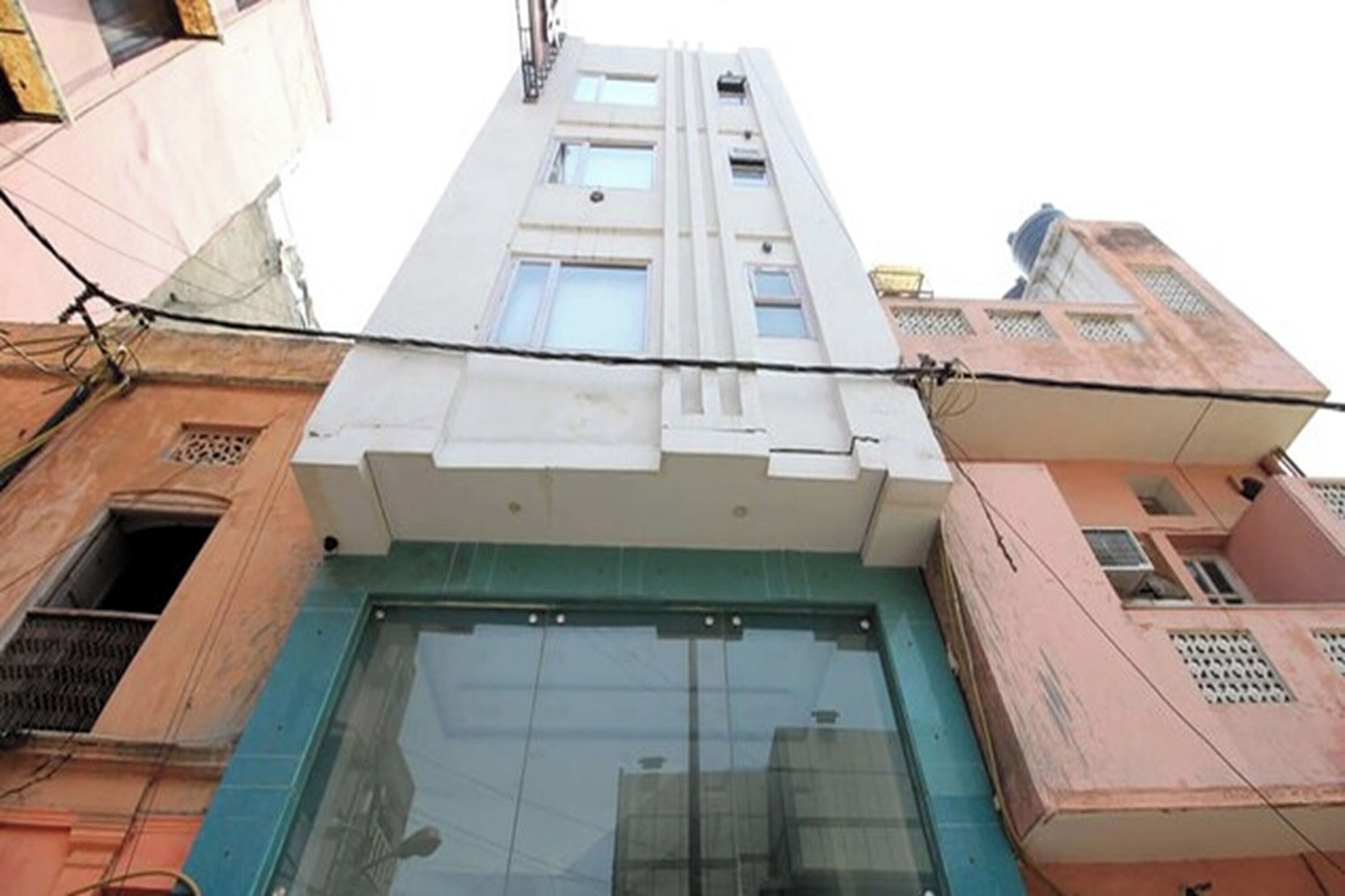 A multi-story building with a large glass entrance and a flat roof.