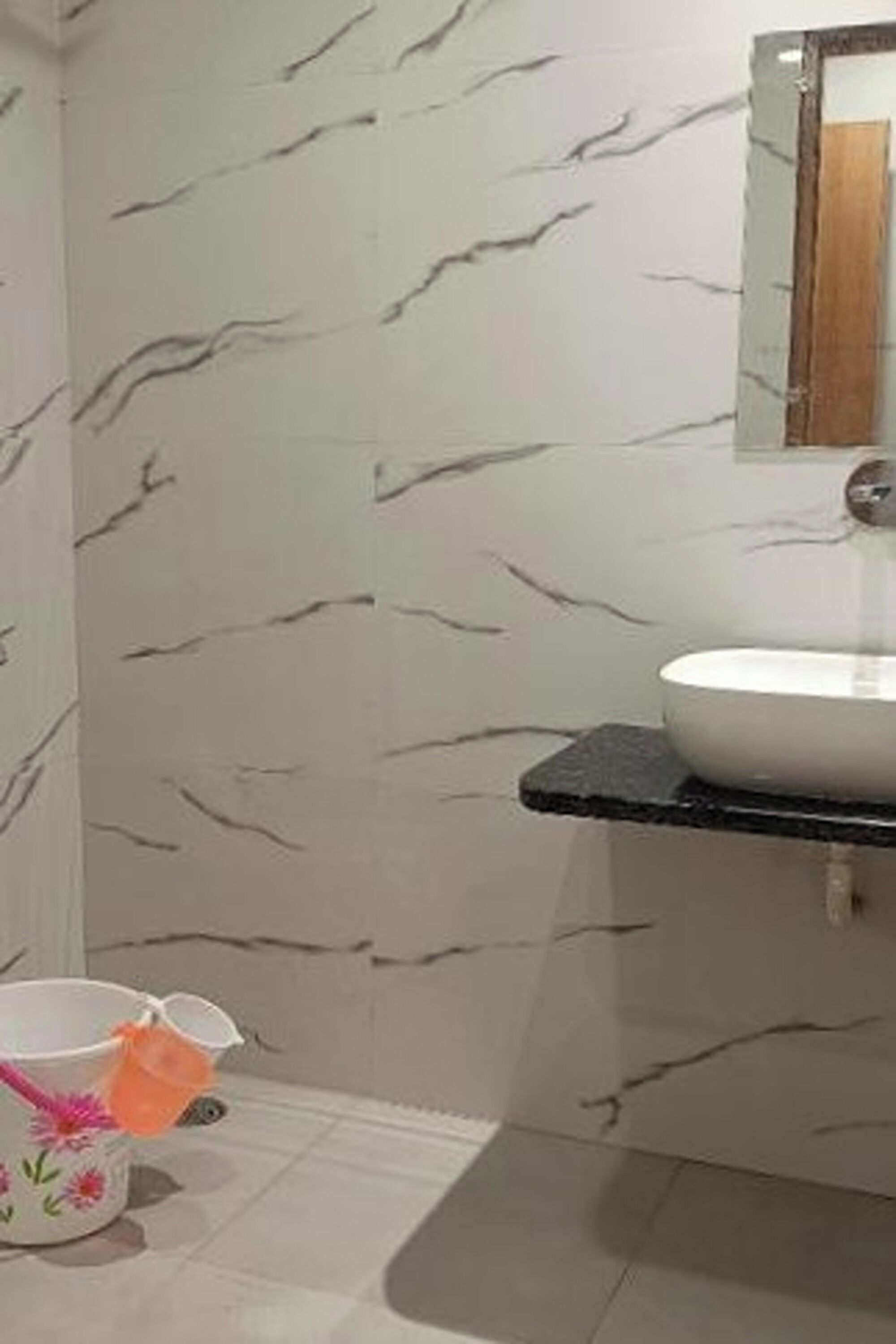 A bathroom with a white marble backsplash, a white sink, and a mirror above it.