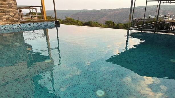 An infinity pool with a clear view of the mountains in the background. - Savitri Bungalow (Jaoli)