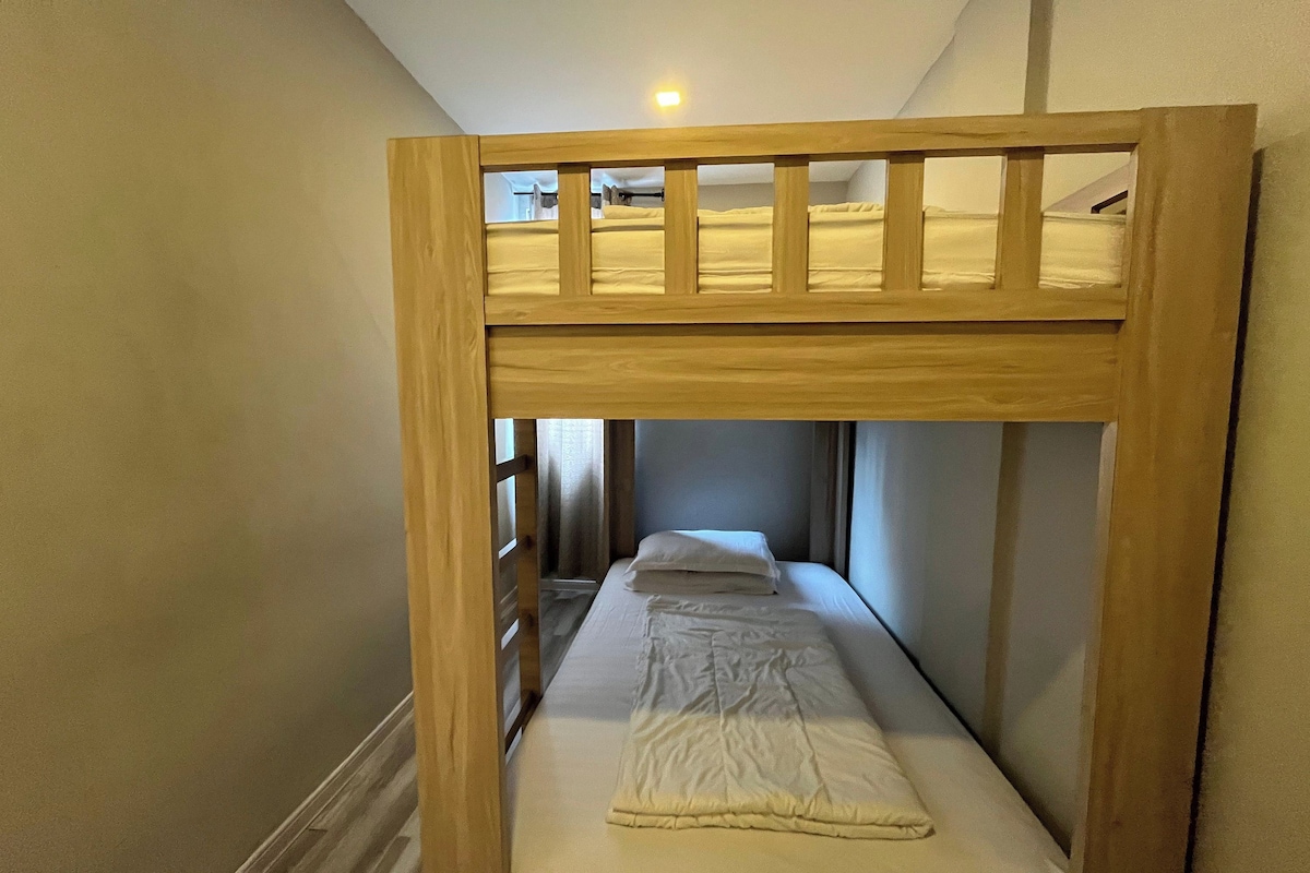 A bunk bed with a wooden frame and a lower bed.