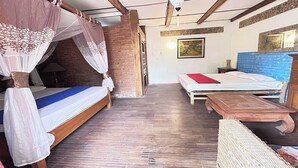A room with a bed, a bench, and a wooden table. - Chez Laelik (Sewon)