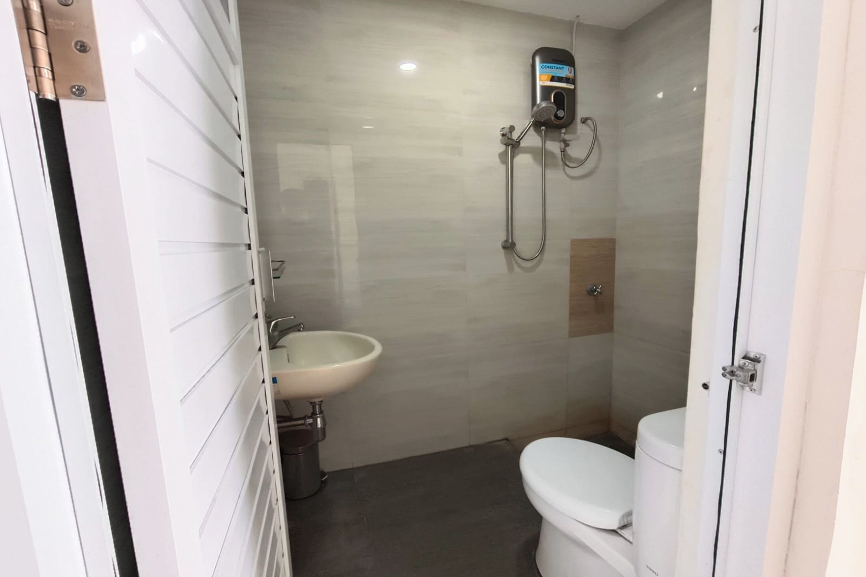 A bathroom with a toilet, sink, and shower.