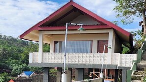 Un bâtiment à deux étages, doté d’un toit rouge et d’un balcon.