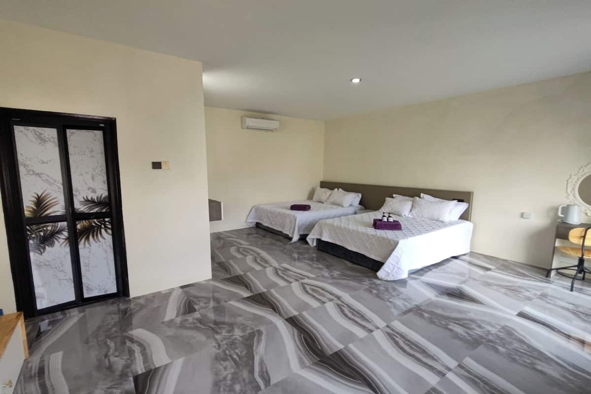 Ein Hotelzimmer mit zwei Betten, Marmorböden, einer Tür mit dekorativer Verkleidung und einer Klimaanlage an der Wand.