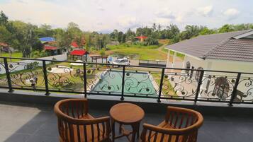Enjoy the serene view of the neighborhood from this balcony, featuring a table and two chairs.