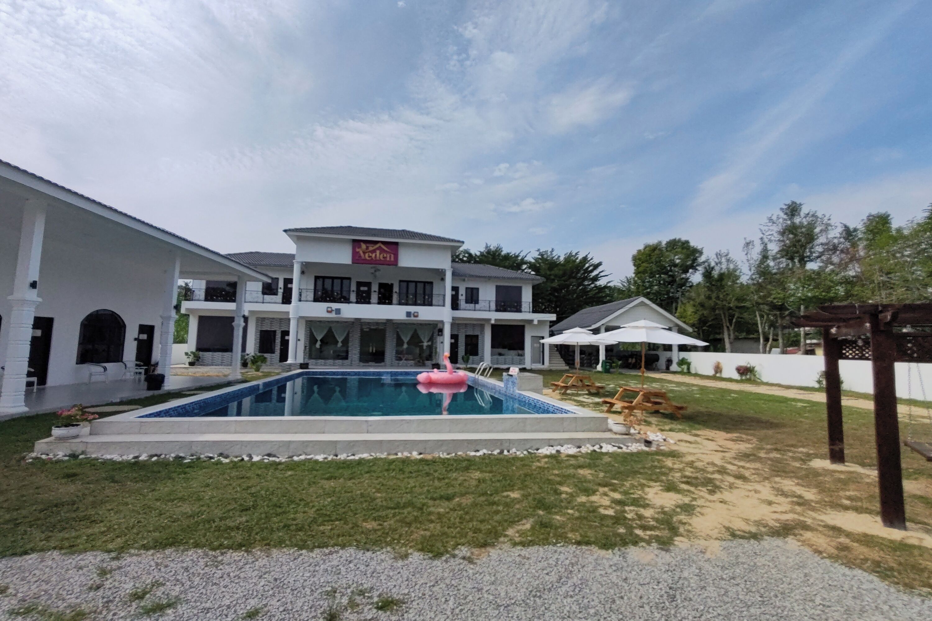 A large, two-story building with a swimming pool in the foreground.