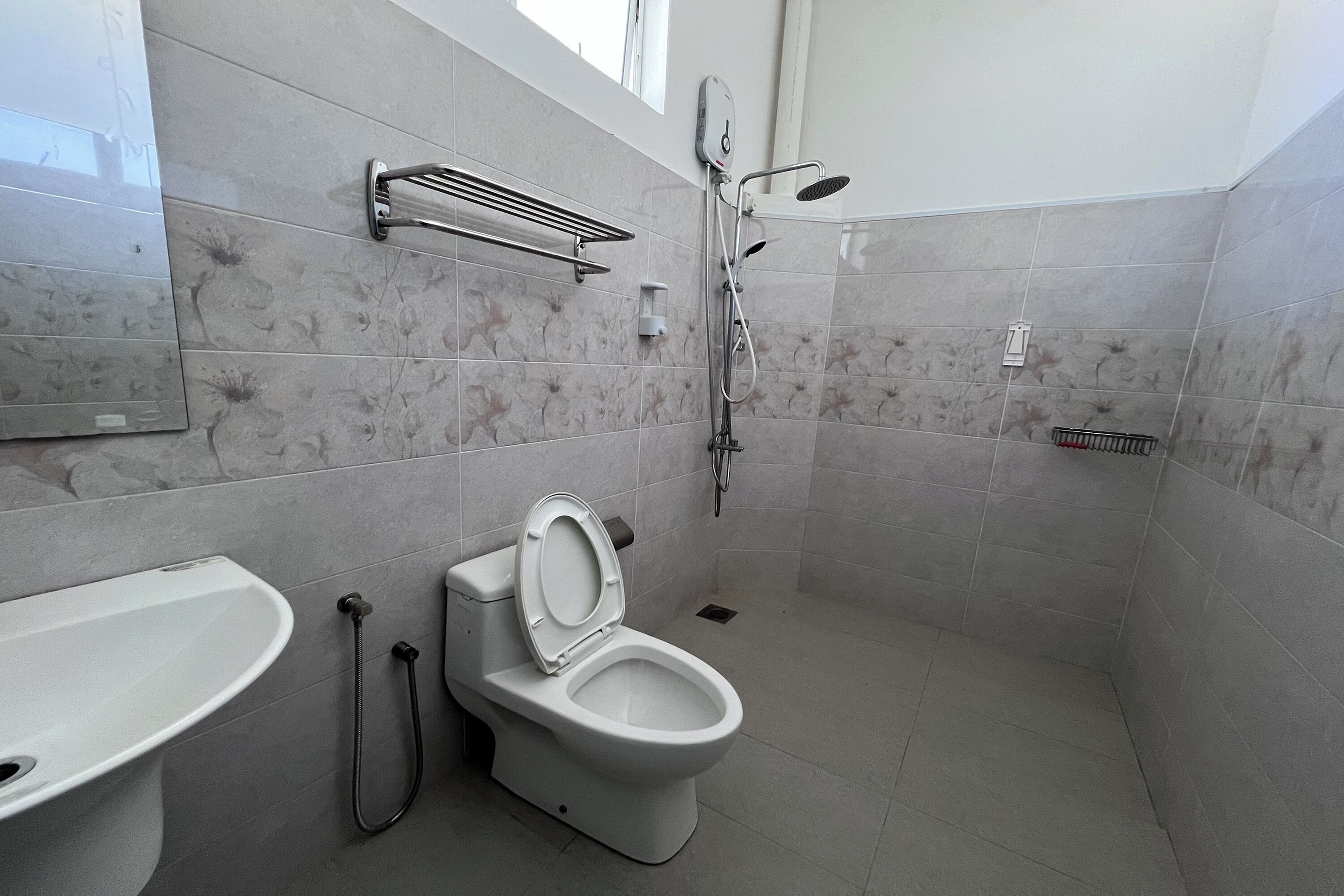 Een moderne badkamer met toilet, wastafel en douche.