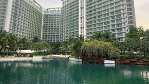 A modern hotel complex with multiple high-rise buildings, a swimming pool, and surrounding greenery. - Budget Suite Paranaque (Parañaque)