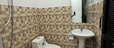 A bathroom with a tiled floor, a toilet, a sink, and a mirror.