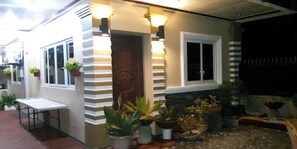 Ein Haus mit Veranda, Tür und Blumentöpfen.