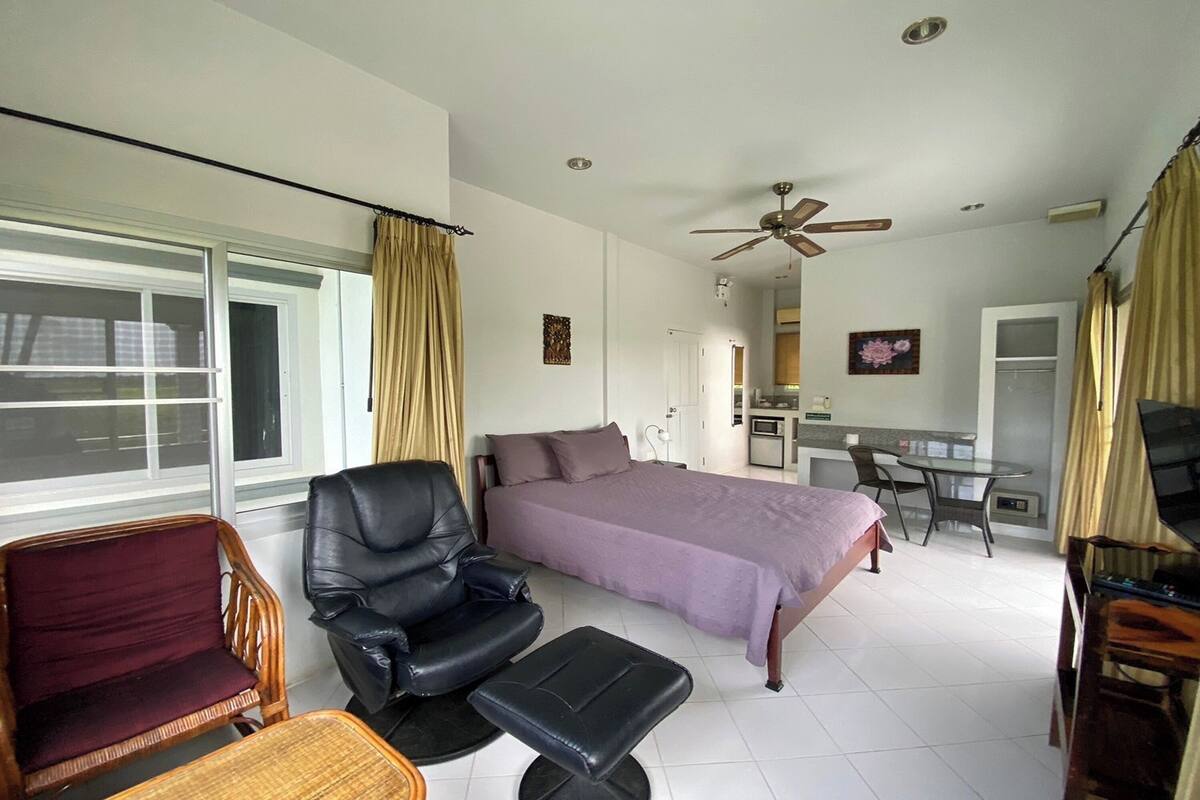 Une chambre à coucher avec un lit, un bureau, une chaise et un canapé.